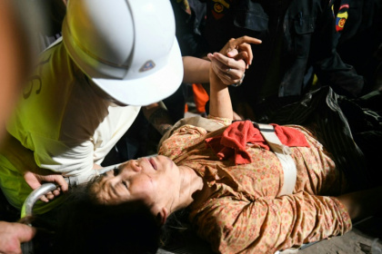 Rescuers pulled a woman alive from the wreckage of a collapsed apartment building in Mandalay