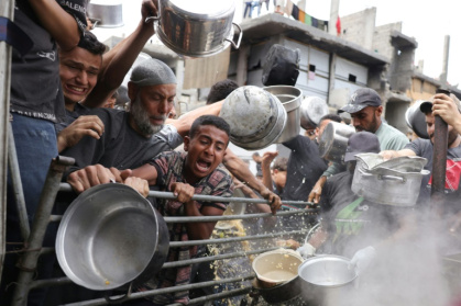 Palestinians struggle to get their food rations at a distribution centre in the northern Gaza Strip - BASHAR TALEB (AFP)