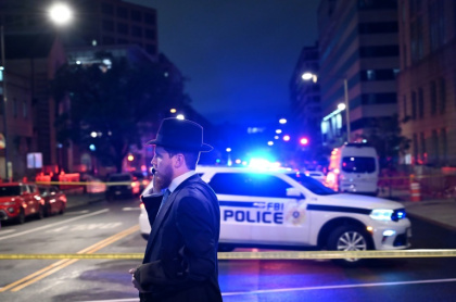 A man, standing behind police tape, talks on his cell phone outside the Capital Jewish Museum following a shooting that left two people dead, in Washington - Alex WROBLEWSKI (AFP)