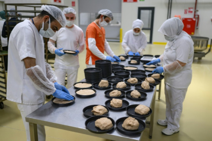 Employees at the Halk Ekmek bakery mix and cut dough for Kulluoba bread, recreating a 5,000-year-old loaf - Yasin AKGUL (AFP)
