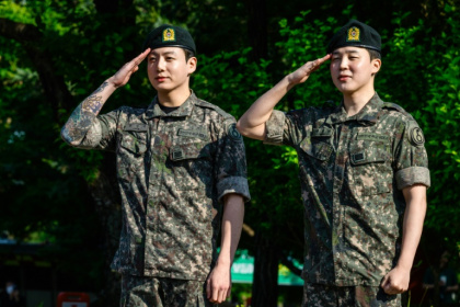 BTS members Jungkook (L) and Jimin (R) salute after their release from South Korean mandatory military service - ANTHONY WALLACE (AFP)