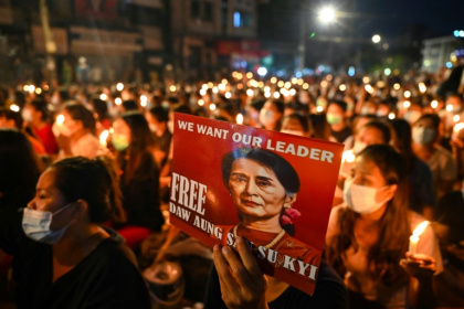A protester holds a poster of Aung San Suu Kyi during a candlelight vigil to honour those who have died during demonstrations against the military coup in Yangon on March 13, 2021 - STR (AFP)