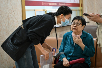 Patient companion Meng Jia with patient Gao Yingmin at a traditional Chinese medicine hospital in Beijing - Jade GAO (AFP)