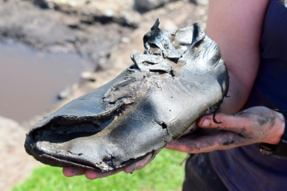 A handout photo released by The Vindolanda Trust shows a complete leather shoe, one of 32 shoes uncovered so far during excavations in Northern England - - (AFP)