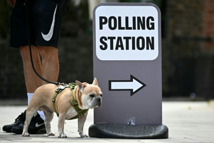A dog stands by a polling station sign in Hackney, east London, on July 4, 2024 when Britain held its last general elections - Paul ELLIS (AFP)