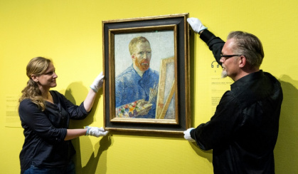 Staff at the Van Gogh Museum in Amsterdam hang a self-portrait of the artist - Koen van Weel (AFP)