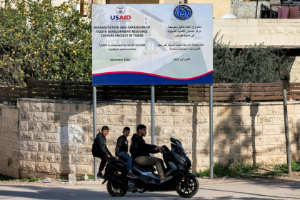 Boys ride behind a man on a scooter past a USAID-funded project for a youth center in Tubas in the north of the occupied West Bank on February 4, 2025 - Jaafar ASHTIYEH (AFP)