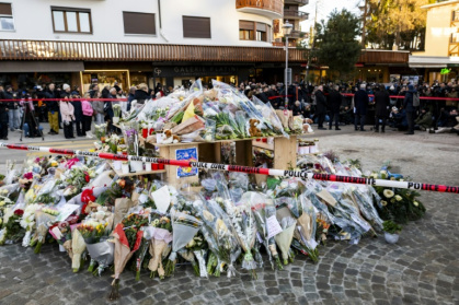 Flowers and candles in tribute to the victims are displayed at a makeshift memorial - JEAN-CHRISTOPHE BOTT (AFP)