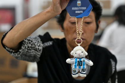A worker packs merchandise of Lionel Messi in China - Hector RETAMAL (AFP)
